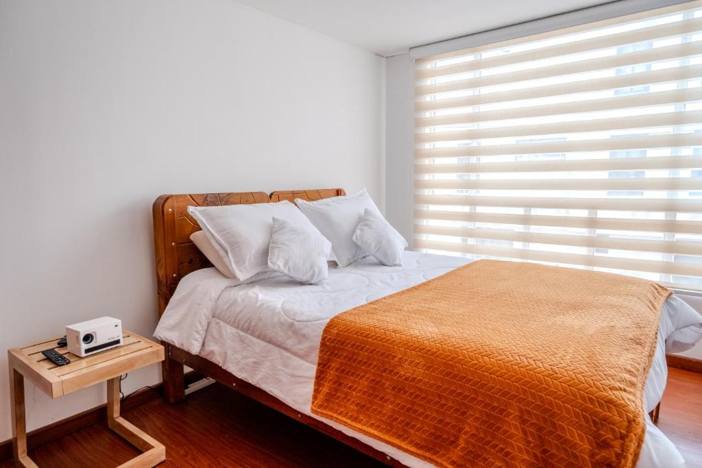 1 dormitorio con 1 cama y ventana con reloj despertador en Sauna Sierra House, en Tunja