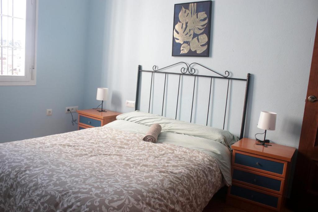 a bedroom with a bed with two nightstands and two lamps at Casa La Romana in Aracena