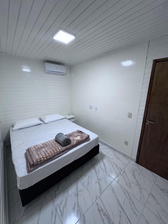 ein Schlafzimmer mit einem Bett in einem weißen Raum in der Unterkunft Seu espaço em floripa! in Florianópolis