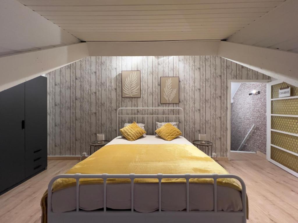 a bedroom with a bed with yellow pillows on it at Maison bel-étage à Wavre in Wavre