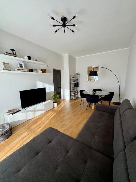 ein Wohnzimmer mit Sofa und Tisch in der Unterkunft Modern Home near Hospital and City Center in Parma