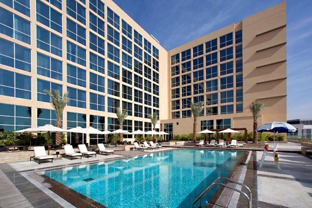 a hotel with a swimming pool in front of a building at Centro Yas Island-by Rotana in Abu Dhabi