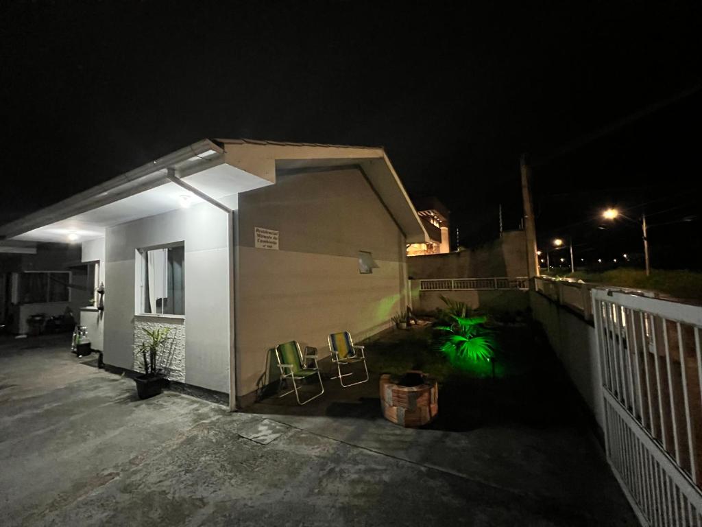 una casa con sillas y una valla por la noche en Hostel Maravilha, en Palhoça