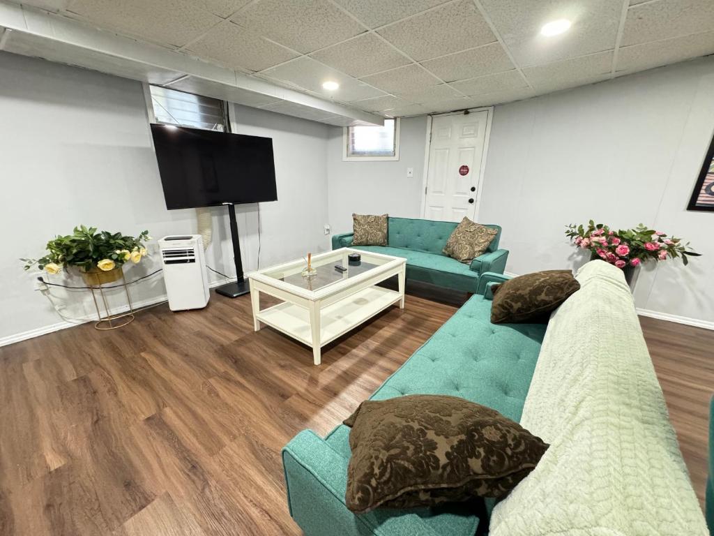 ein Wohnzimmer mit Sofas und einem Flachbildfernseher in der Unterkunft Cozy 1 bedroom close to NYC with private bar in North Bergen