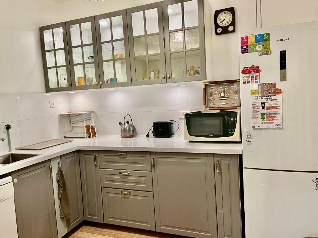 une cuisine avec un réfrigérateur et un micro-ondes dans l'établissement Cozy pavillon quartier Laplace, Maison des examens, à Arcueil