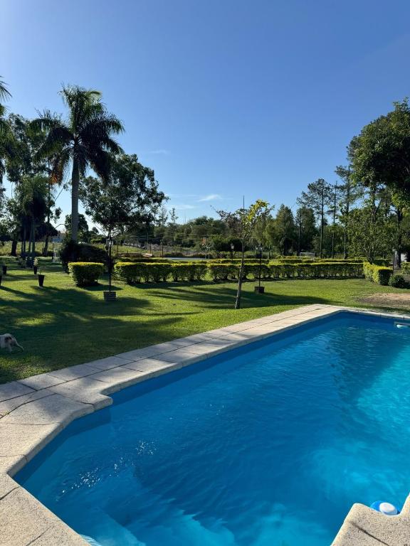 科连特斯El Refugio Lodge的绿树成荫的公园里的一个蓝色游泳池