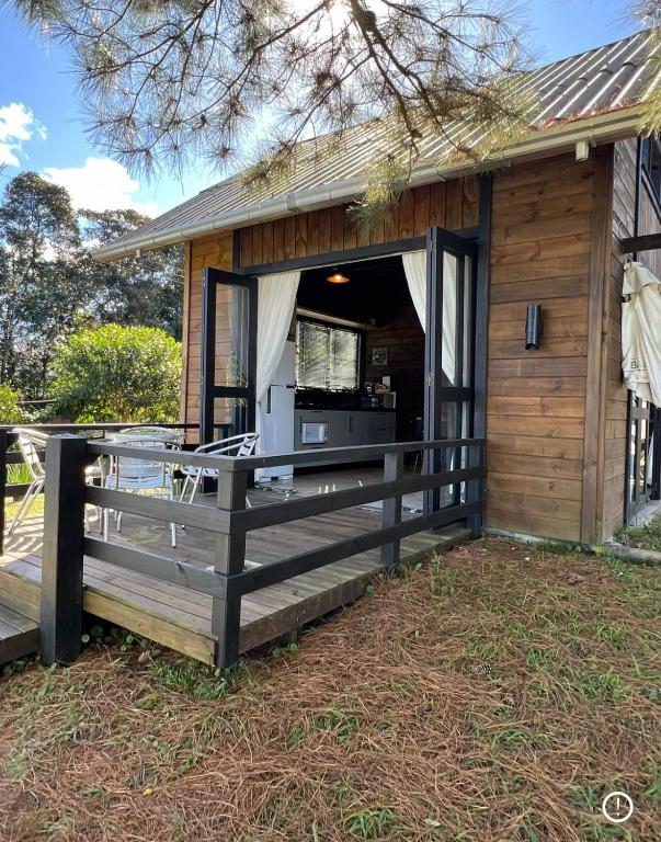 a small cabin with a porch and a deck at Cabana Trinca Ferro in São Pedro de Alcântara