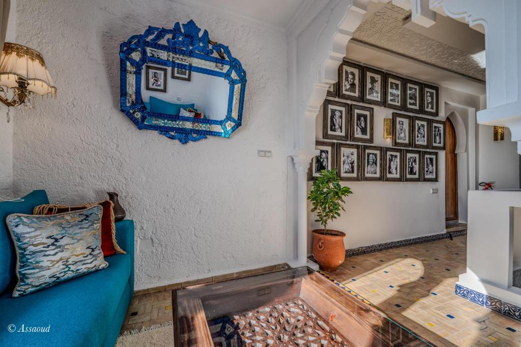 a living room with a blue couch and a mirror at Dar Bleumain in Chefchaouen