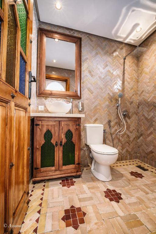 a bathroom with a toilet and a sink and a mirror at Dar Bleumain in Chefchaouen