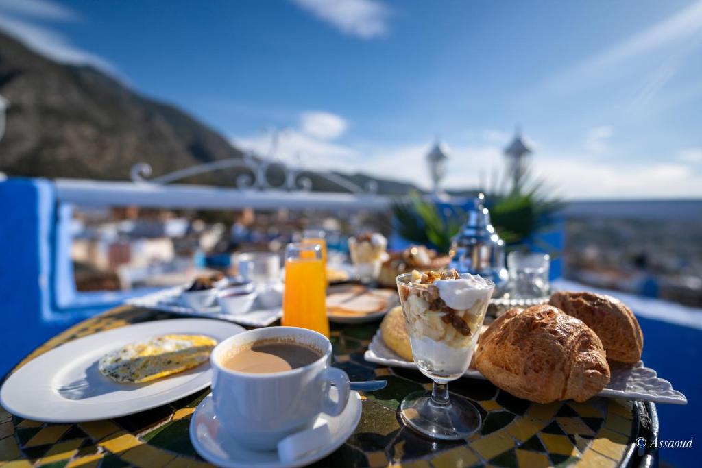 a table with a plate of food and a cup of coffee at Dar Bleumain in Chefchaouen