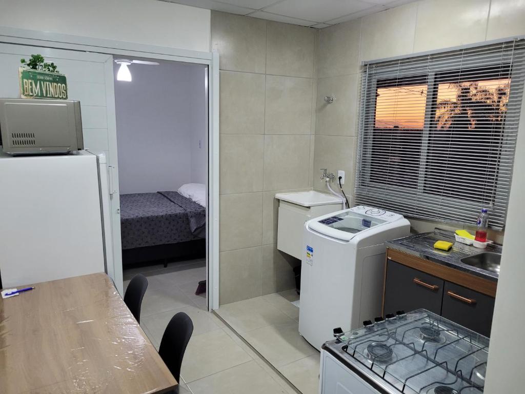 Una pequeña cocina con fregadero y refrigerador. en Stúdio Aconchegante, en Santa Maria