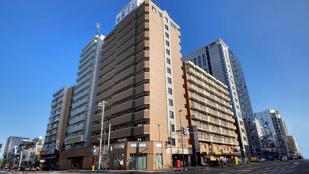 a tall building on a city street with tall buildings at Toyoko Inn Hokkaido Sapporo-eki Nishi-guchi Hokudai Mae in Sapporo