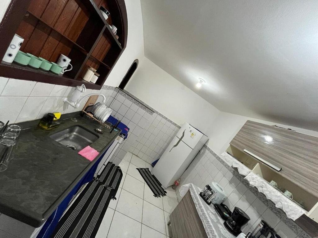 a small kitchen with a sink and a refrigerator at Flat na beira da praia in Maricá