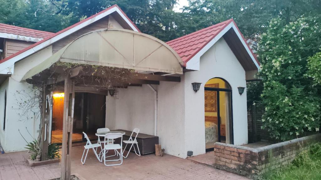 a small white house with a table and chairs at Casa encantadora con servicio de transporte al Aeropuerto in Osorno