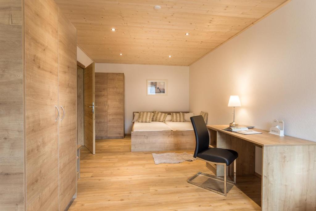 a home office with a desk and a bedroom at Appartements Lilly Rose in Zell am Ziller