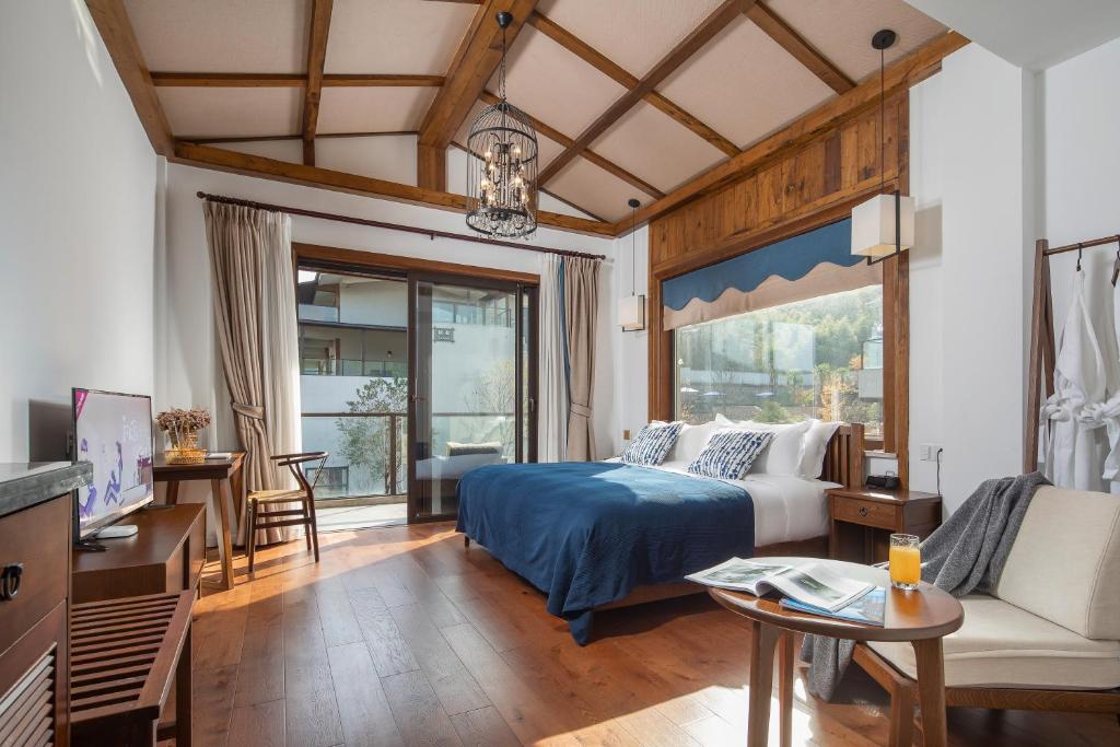 a bedroom with a bed and a living room at 莫干山缦田生态度假酒店 in Deqing