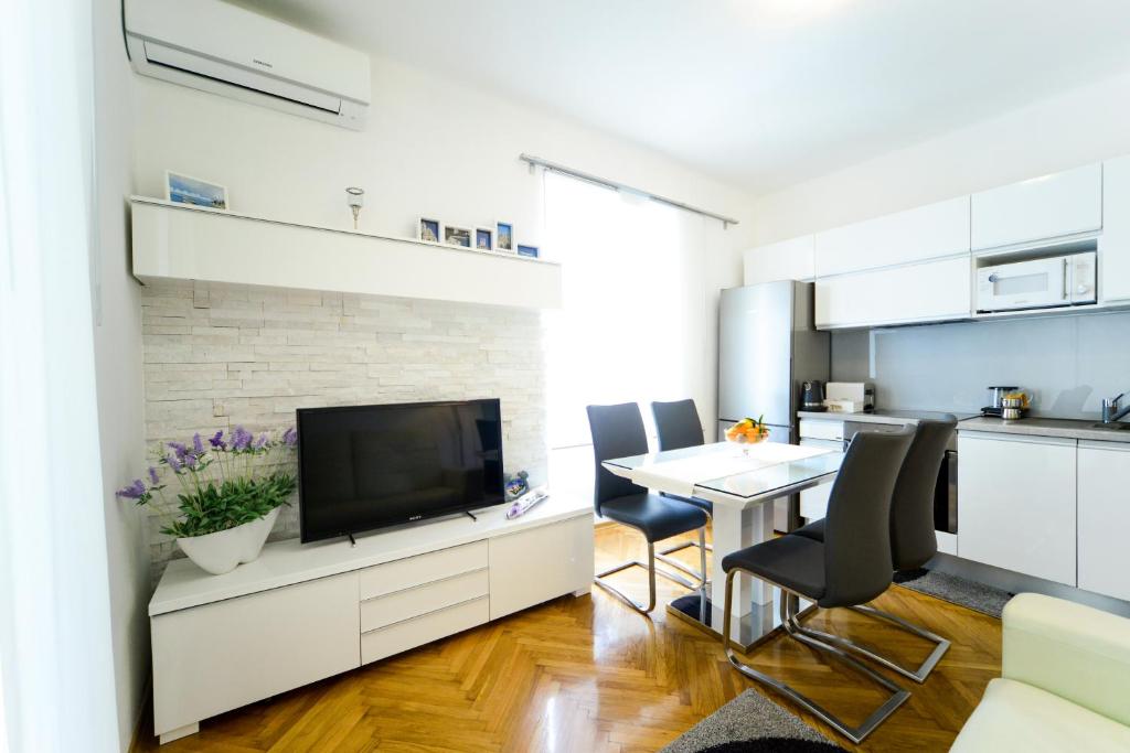 cocina y sala de estar con TV y mesa en Central Palace Apartment, en Zadar