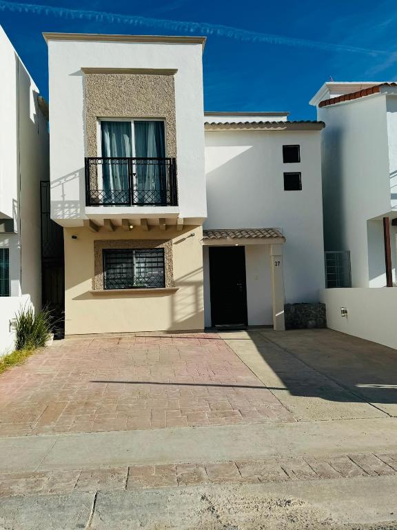 a white house with a balcony and a driveway at Casa Castaño Cd Jrz in Ciudad Juárez