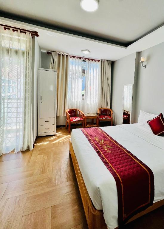 a hotel room with a large bed and a table at Dalat ECO Hotel 2 in Da Lat