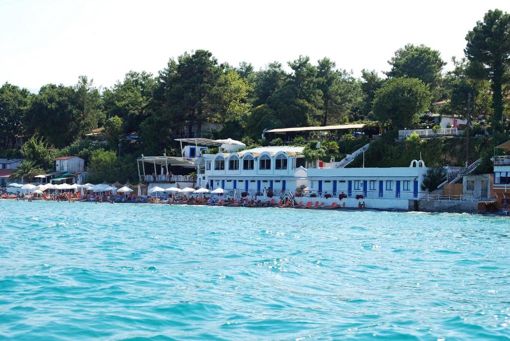 un complejo a orillas de un cuerpo de agua en Olympos Beach en Plaka Litochorou