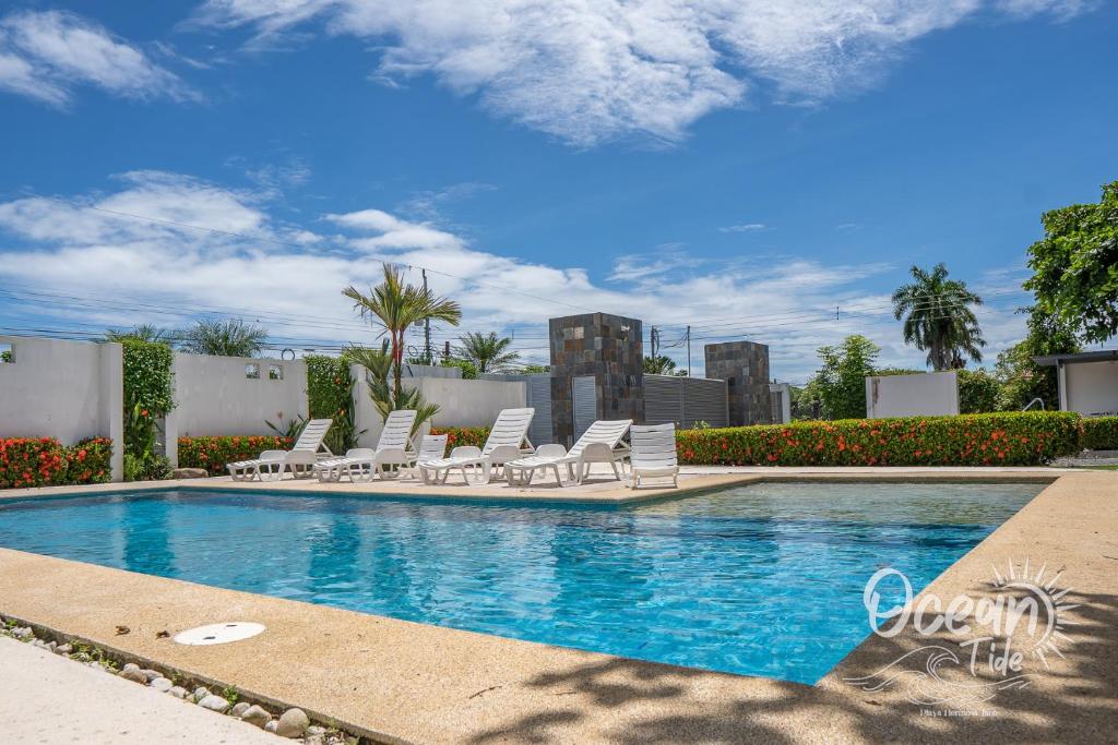 a swimming pool with lounge chairs and a swimming pool at Oceantide Playa Hermosa in Playa Hermosa