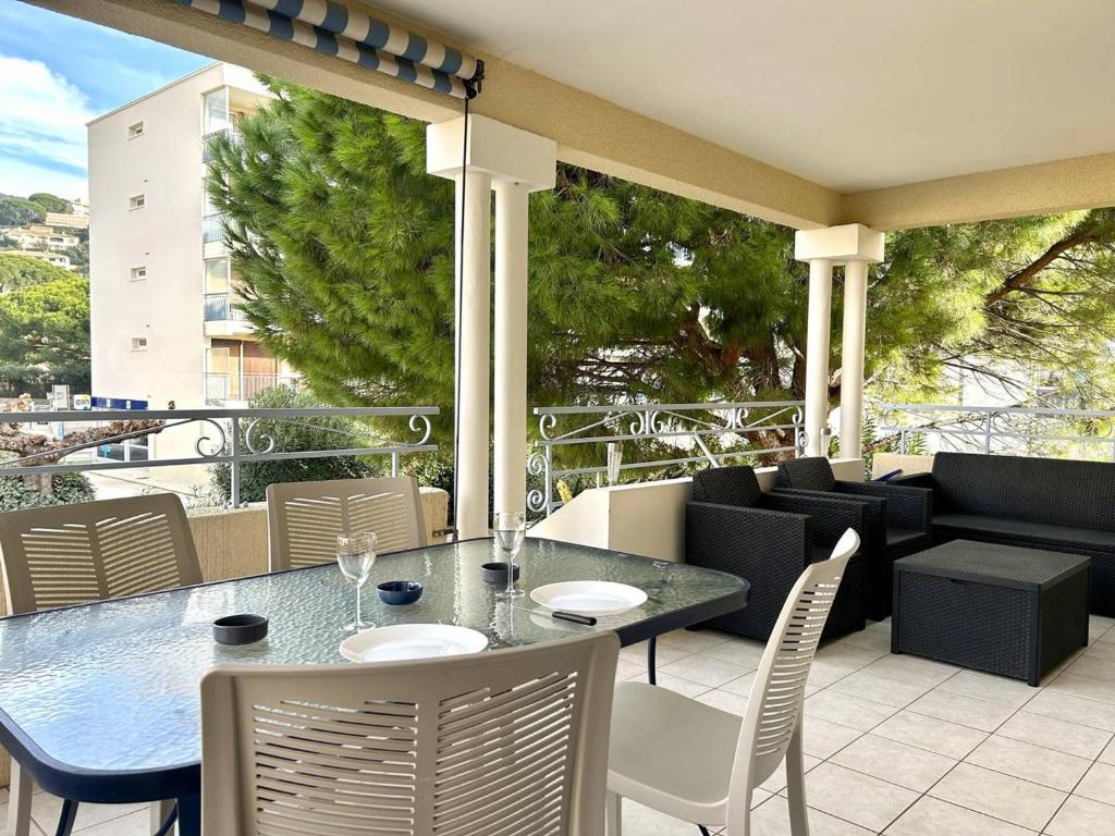 un patio avec une table et des chaises sur un balcon dans l'établissement Appartement climatisé 2 pièces avec terrasse et parking au Lavandou - FR-1-251-854, au Lavandou