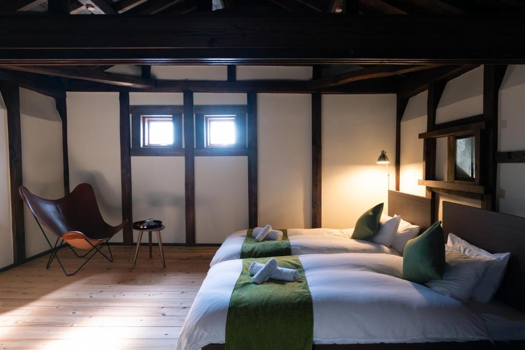Postel nebo postele na pokoji v ubytování Nunoya Ryokan