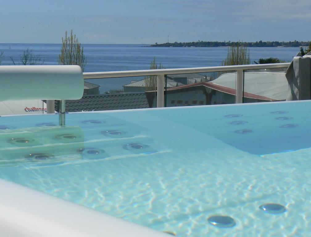 bañera de hidromasaje en el balcón con vistas al agua en Camping Les Sables Blancs, en Concarneau