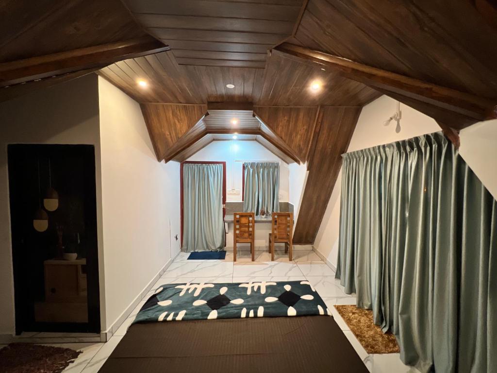 バガモンにあるVerdant peaks Homestayのベッドとテーブルと椅子のある部屋
