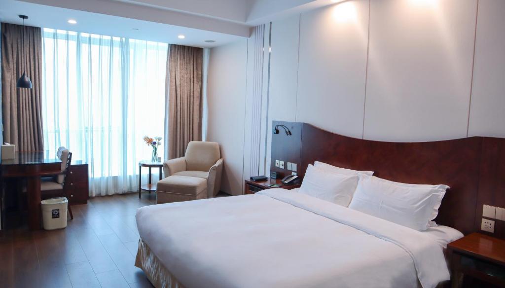 Postel nebo postele na pokoji v ubytování Shanghai Metropark Jichen Hotel