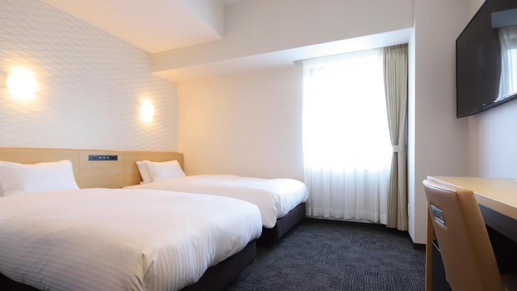 Postel nebo postele na pokoji v ubytování AB Hotel Konan