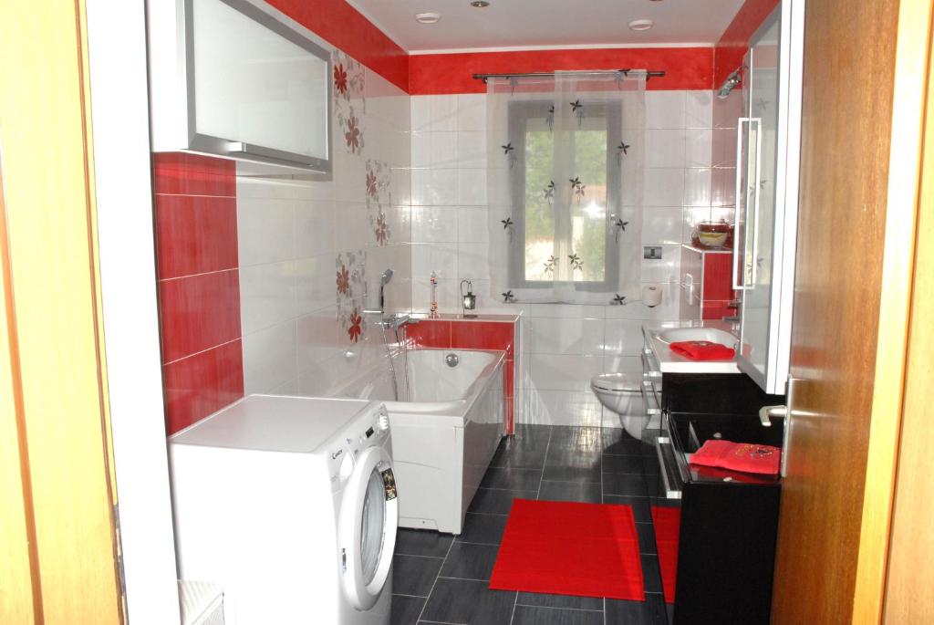 czerwono-biała łazienka z wanną i toaletą w obiekcie Holiday Home Villa Margherita w Puli