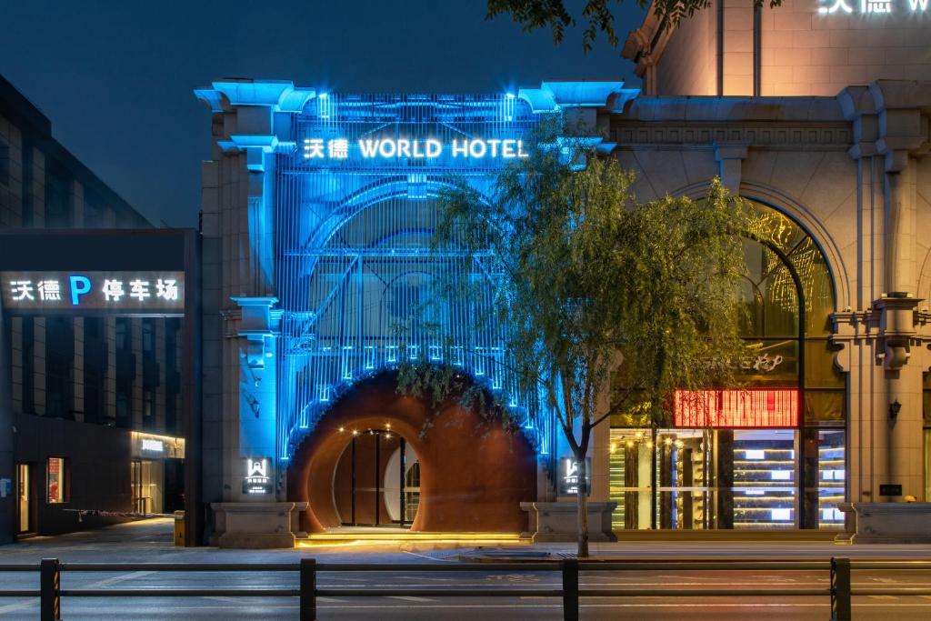 un edificio con una señal azul en él por la noche en 沃德酒店济南泉城广场大明湖店, en Jinan
