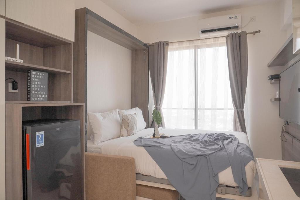 ein kleines Schlafzimmer mit einem Bett und einem Fenster in der Unterkunft Best Choice and Cozy Studio Sky House BSD Apartment By Travelio in Tangerang
