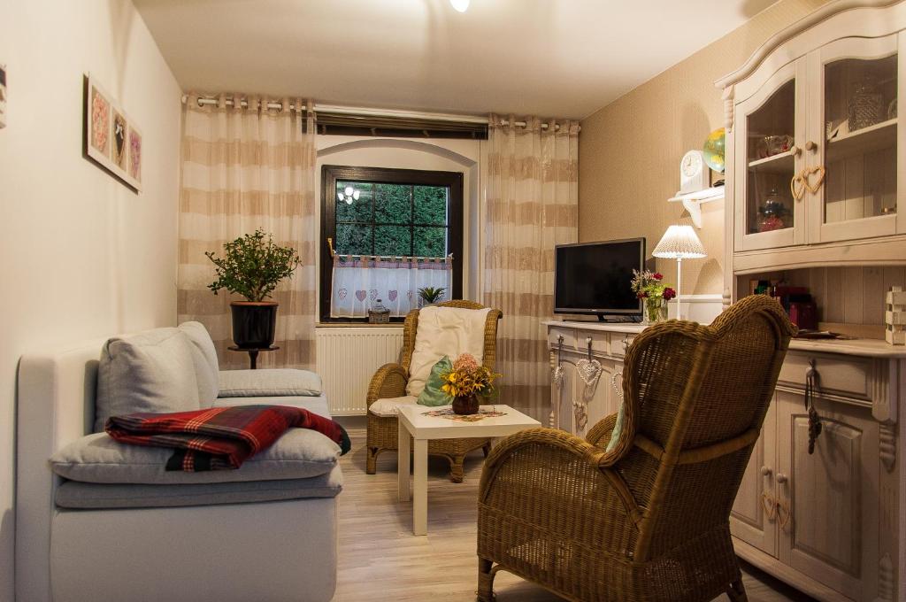 ein Wohnzimmer mit 2 Stühlen und einem TV in der Unterkunft Romantik Landhaus in Dresden