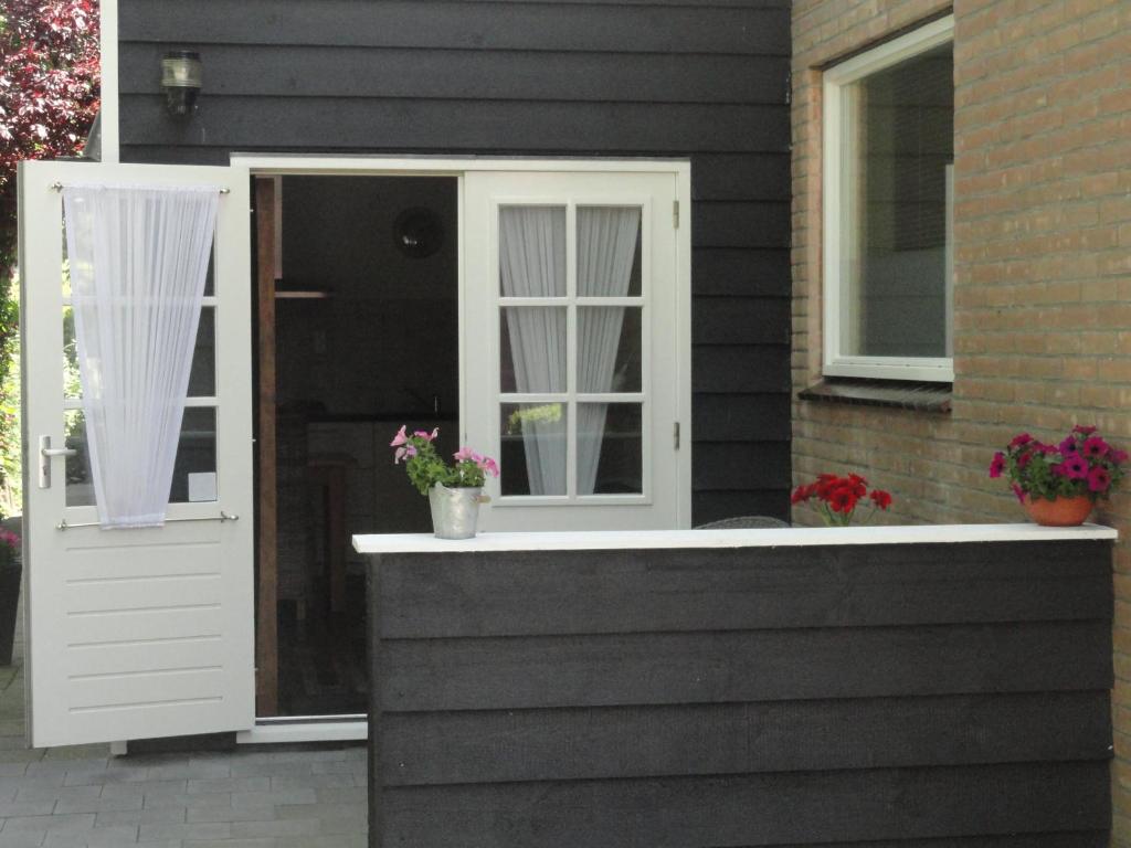 ドンブルグにあるAppartement Schuitvlotの白いドアと窓のある家