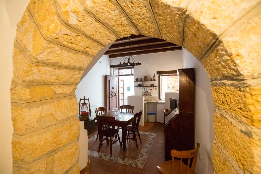 comedor y cocina con pared de piedra en Bilocale Mandralisca, en Cefalú