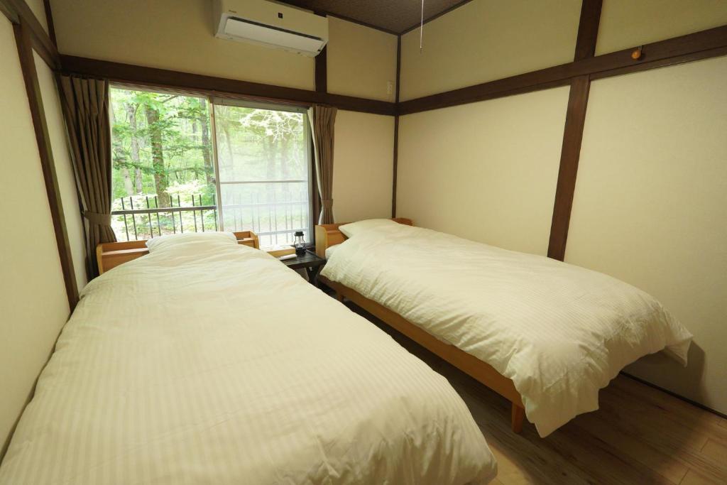 Postel nebo postele na pokoji v ubytování Kitakaruizawa Isshoan ~北軽井沢 一菖庵~