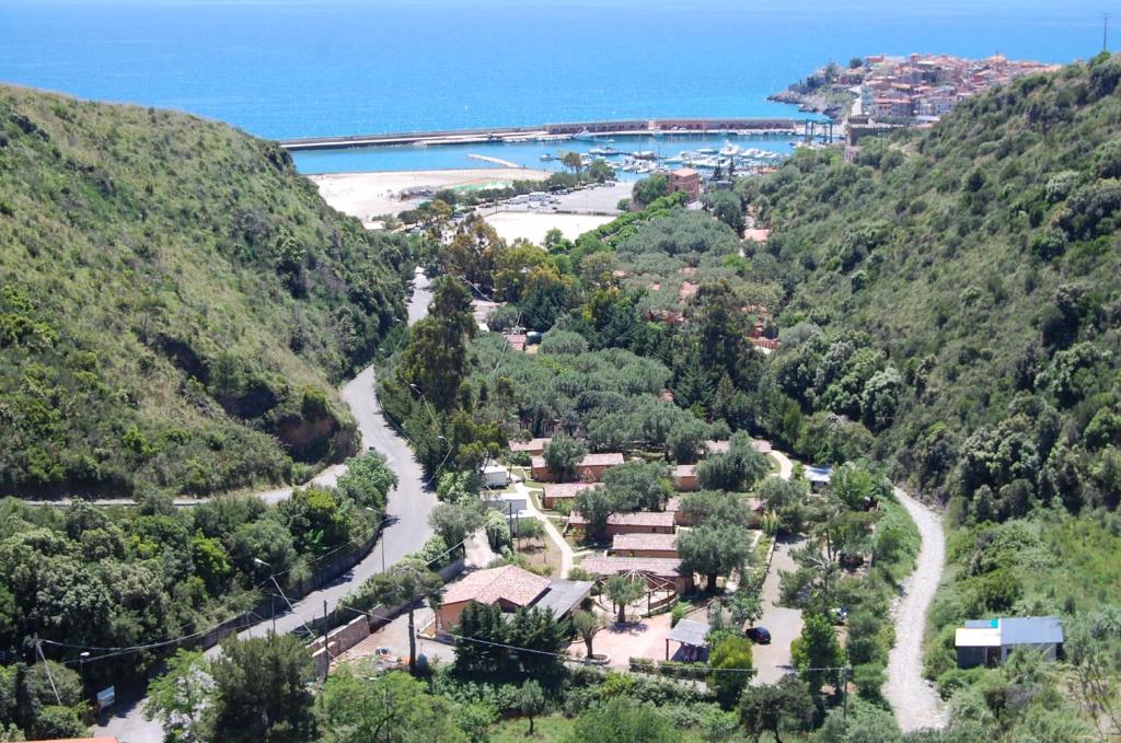an aerial view of a village on a hill with a beach at Family Resort Cala di Luna in Marina di Camerota