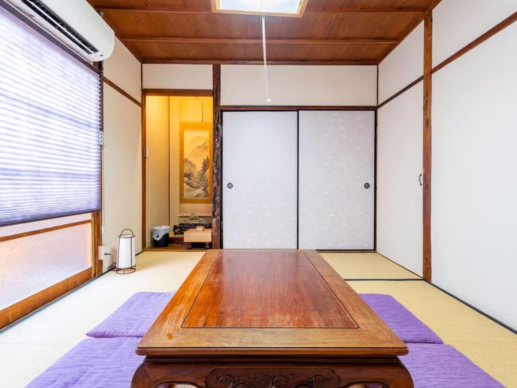 a room with a wooden table in front of a door at sano no yado - 佐野の宿 - in Sano