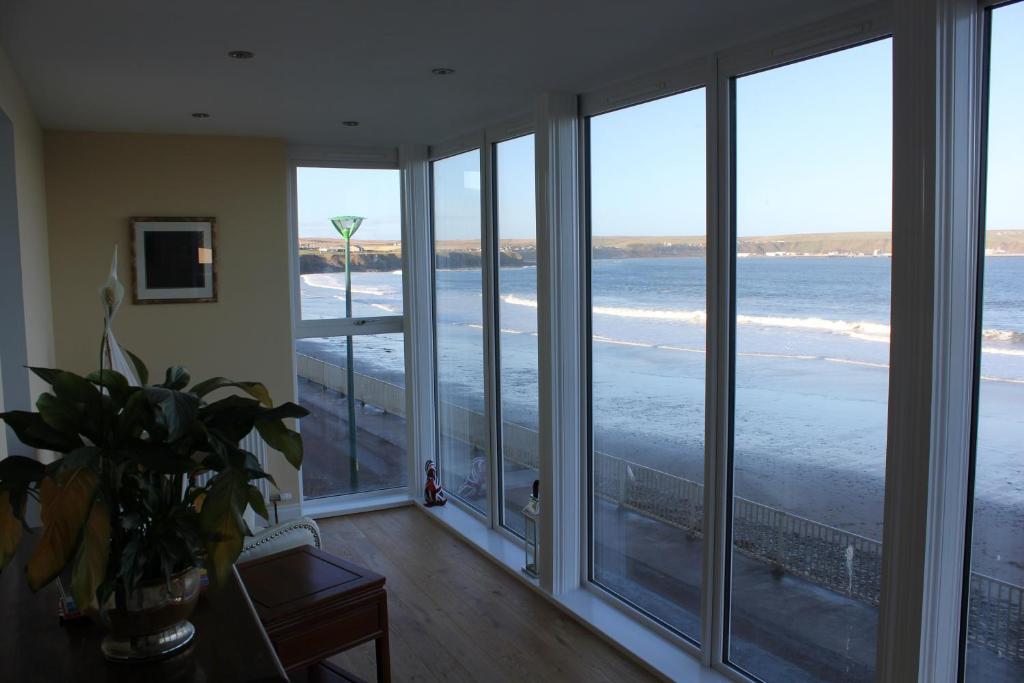 a room with large windows looking out at the ocean at The Marine in Thurso
