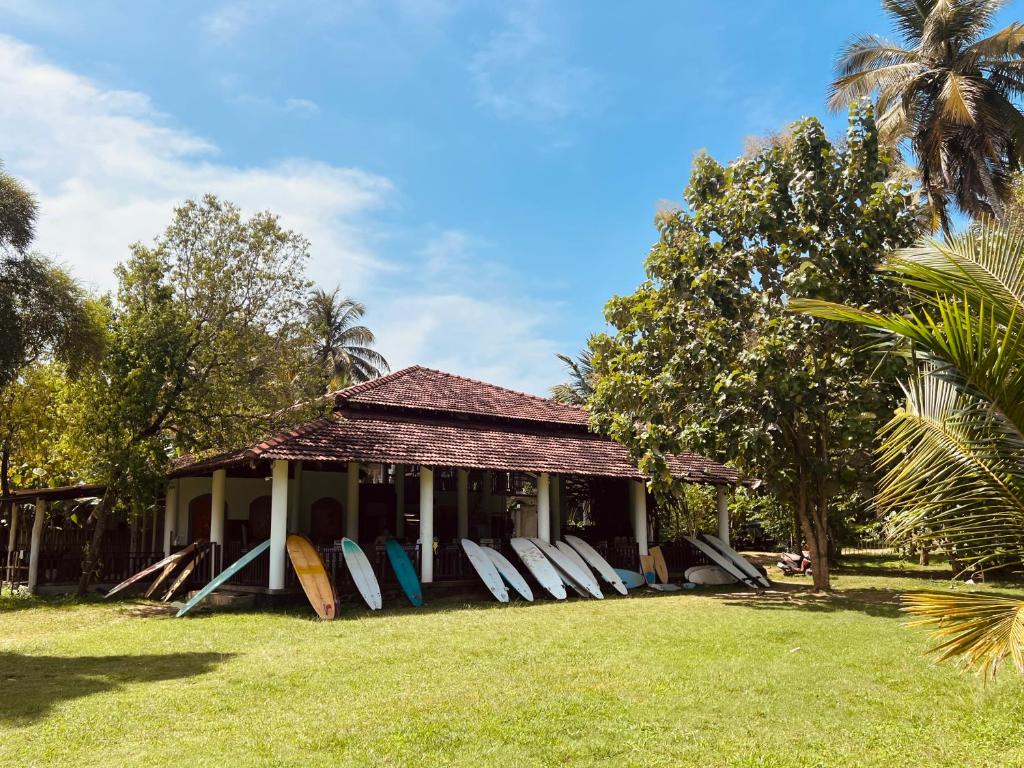 a group of surfboards are lined up outside of a house at Calma - Surf, Yoga & Coffee on a Private Beach in Dickwella