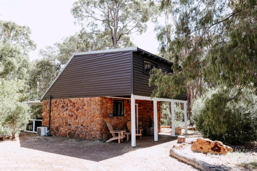 a small stone house with a black roof at Cottage 1 - The Row in Forest Grove