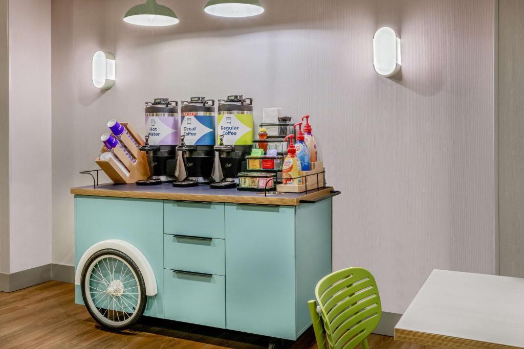 a cart in a room with a table and chairs at Spark by Hilton Denver International Airport in Denver