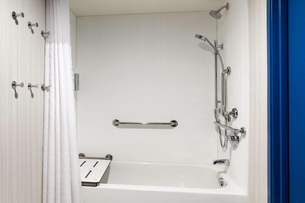 a white bathroom with a tub and a shower at Spark by Hilton Denver International Airport in Denver