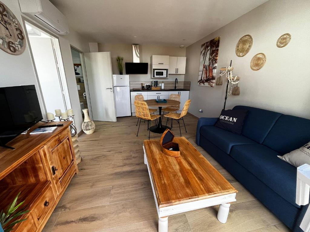un salon avec un canapé bleu et une table dans l'établissement Sun Oasis Les Tamaris, à Bretignolles-sur-Mer