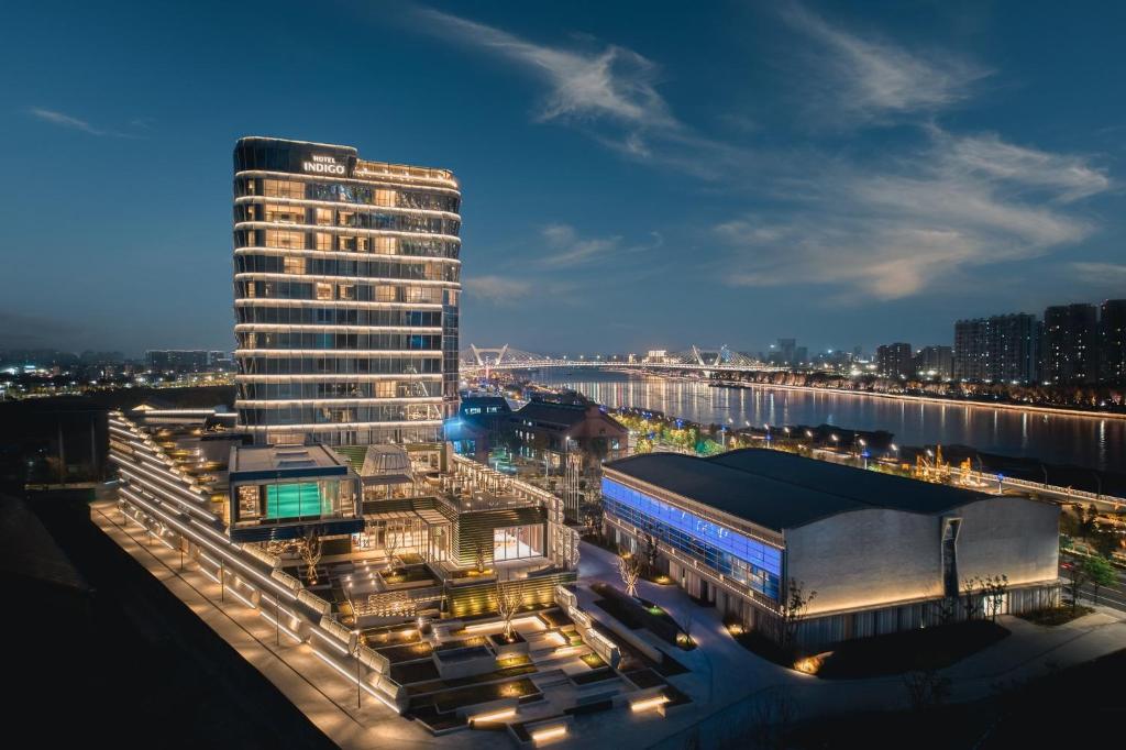 a view of a building at night with a city at Hotel Indigo Ningbo Riverside by IHG in Ningbo