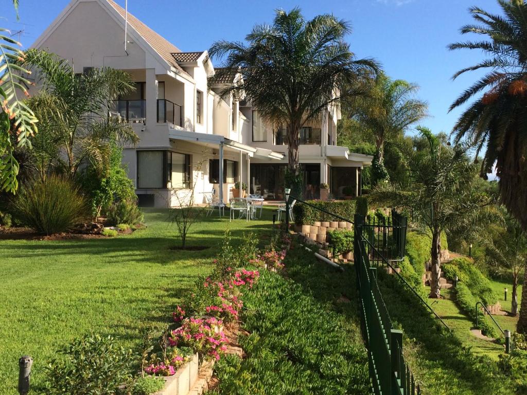 a house with a fence in front of a yard at Oewerpalms View in Oudtshoorn