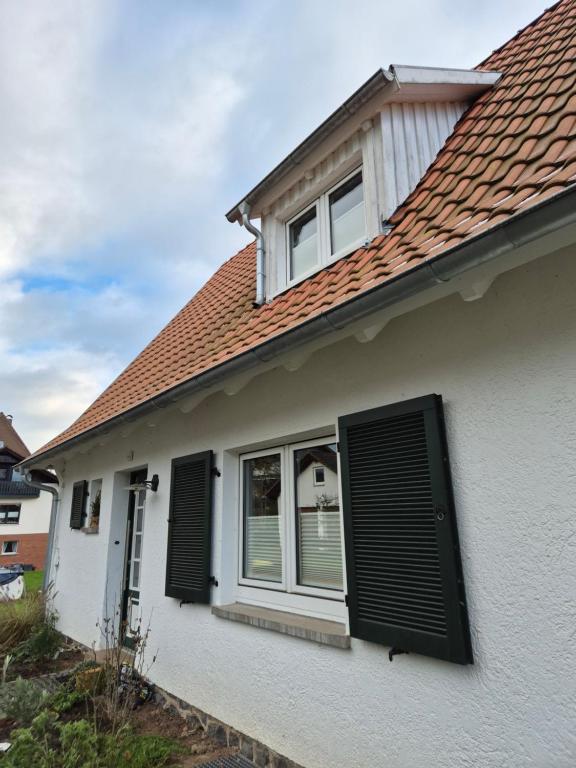 una casa bianca con persiane nere di Charmantes Ferienhaus in Alsfeld-Eifa ad Alsfeld
