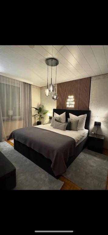 a bedroom with a large bed and a chandelier at FeWo Elisabeth am Harztor in Osterode